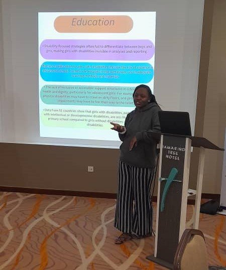 Woman presenting at the SPADRA workshop. Behind her the screen says "Education".