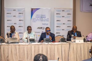 Photograph of attendants of the conference facing a panel of speakers. 