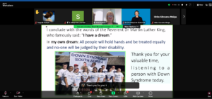 A Zoom webinar screenshot shows a slide presentation with an inspirational quote referencing Martin Luther King Jr.'s 'I have a dream' speech. The slide expresses a vision for equality, stating, 'All people will hold hands and be treated equally, and no one will be judged by their disability.' Below the text is a photo of a group of people with Down syndrome wearing matching white t-shirts and standing together in front of a banner that reads 'Down Syndrome South Africa.' The slide also thanks the audience for listening to a person with Down syndrome. The Zoom interface displays multiple participants, including interpreters, a speaker named Sheri Brynard, and a raised hand from a participant.