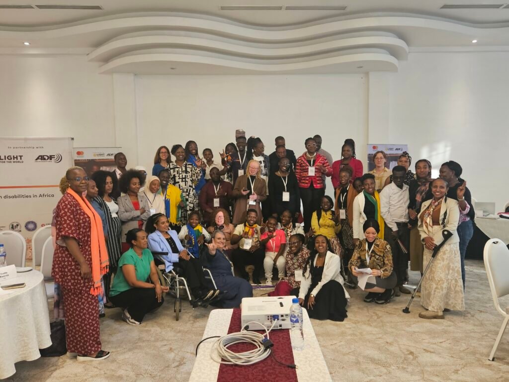 Young leaders with disabilities and facilitators gather joyfully during the Youth Leadership Programme contact workshop in Addis Ababa, smiling, raising hands, and celebrating their shared leadership journey