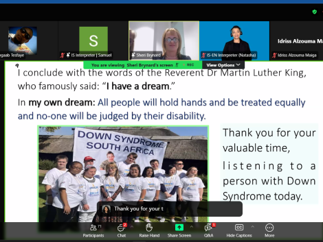 A Zoom webinar screenshot shows a slide presentation with an inspirational quote referencing Martin Luther King Jr.'s 'I have a dream' speech. The slide expresses a vision for equality, stating, 'All people will hold hands and be treated equally, and no one will be judged by their disability.' Below the text is a photo of a group of people with Down syndrome wearing matching white t-shirts and standing together in front of a banner that reads 'Down Syndrome South Africa.' The slide also thanks the audience for listening to a person with Down syndrome. The Zoom interface displays multiple participants, including interpreters, a speaker named Sheri Brynard, and a raised hand from a participant.