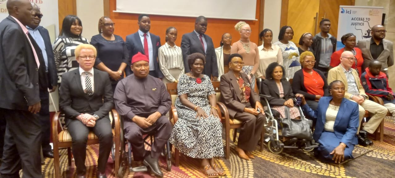 A diverse group picture with people sitting and people standing behind them.