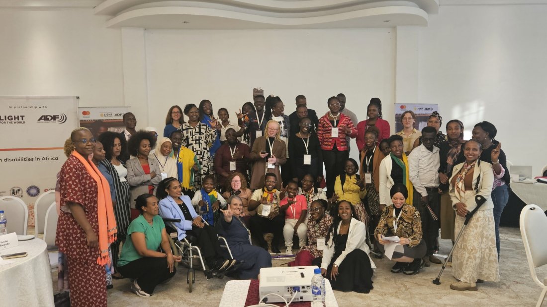 Young leaders with disabilities and facilitators gather joyfully during the Youth Leadership Programme contact workshop in Addis Ababa, smiling, raising hands, and celebrating their shared leadership journey