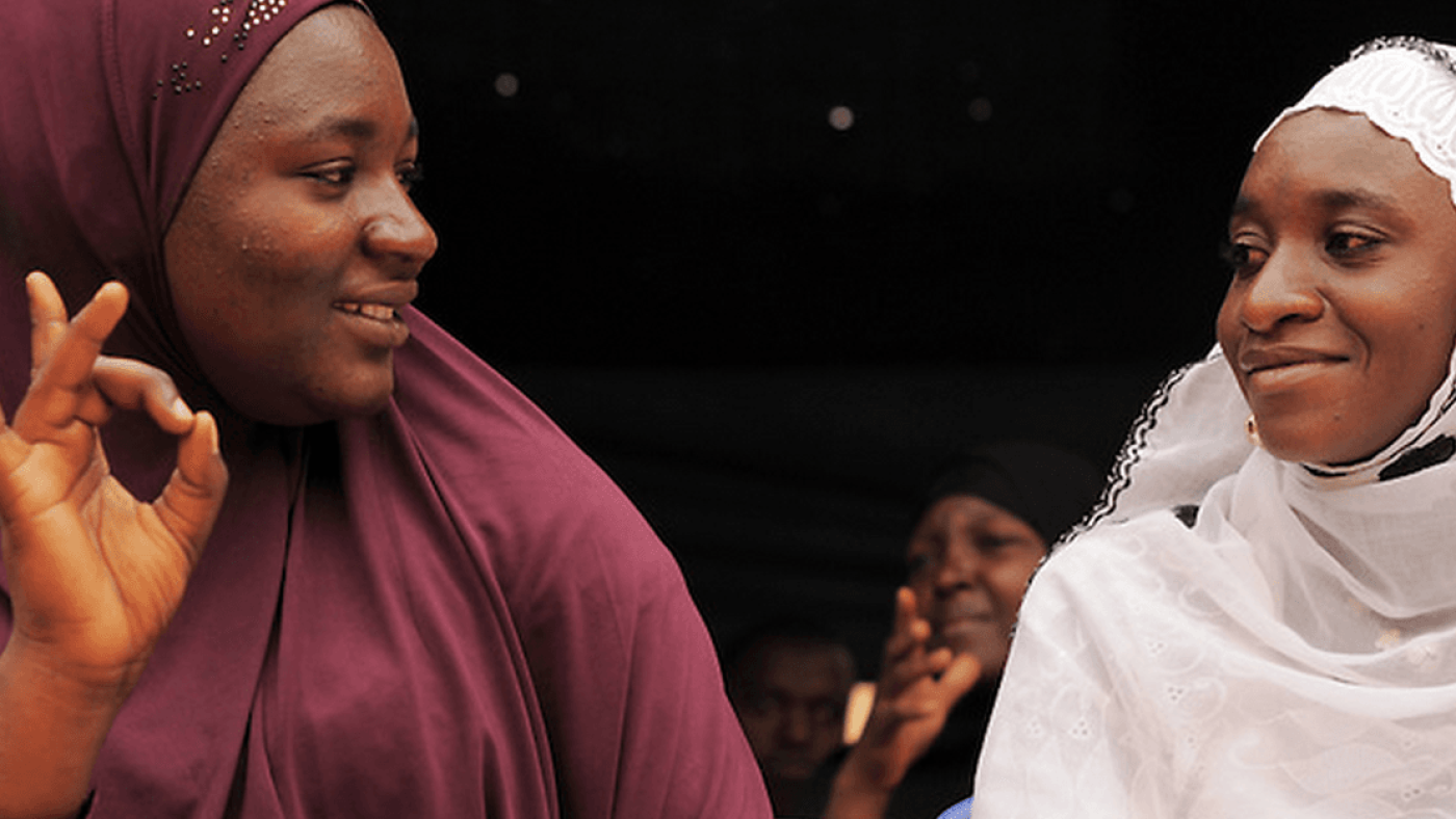 2 women are looking at each other smiling