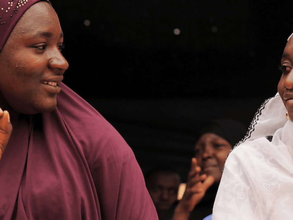 2 women are looking at each other smiling